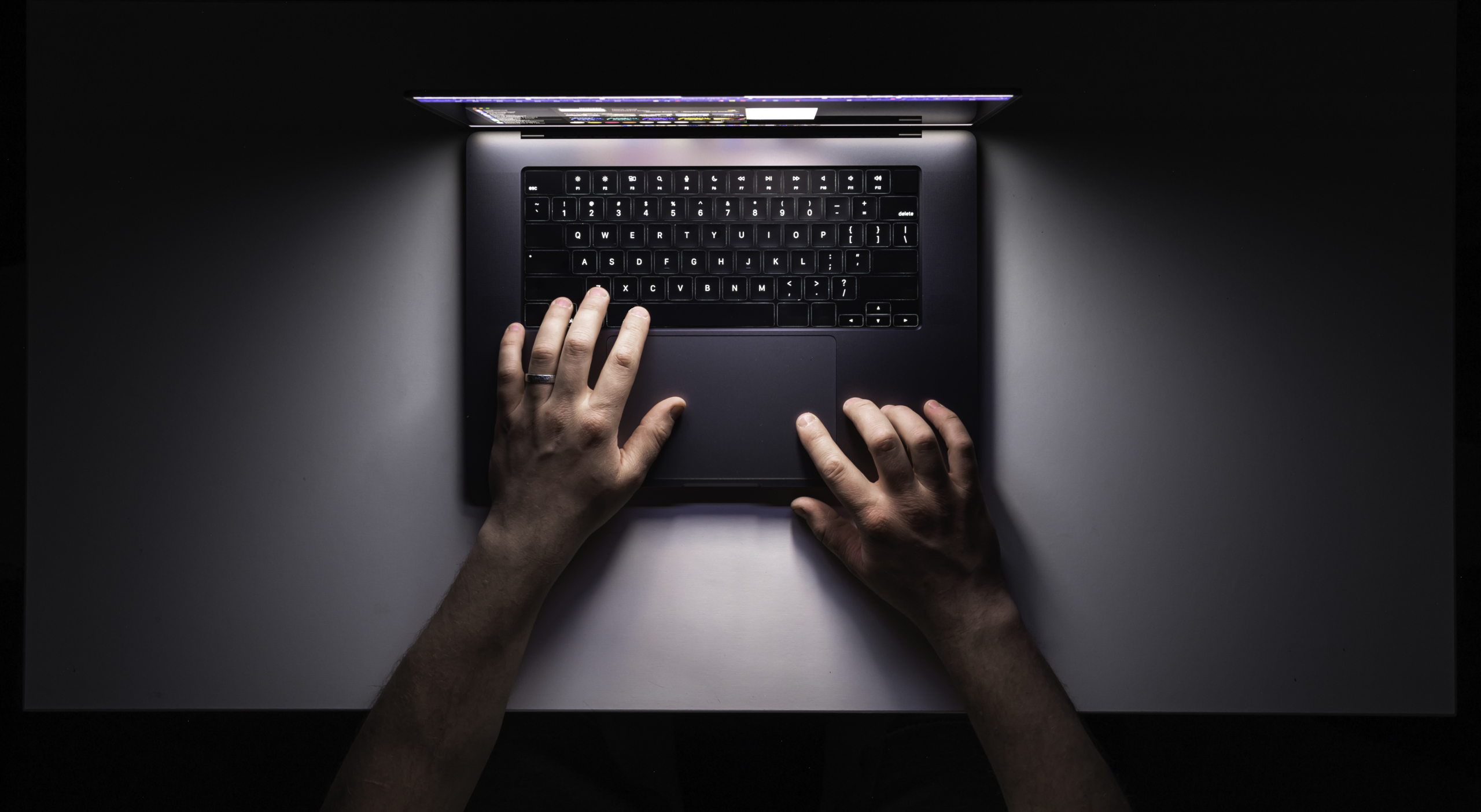 Getrouwde man gebruikt geheimzinnig zijn laptop in het donker.